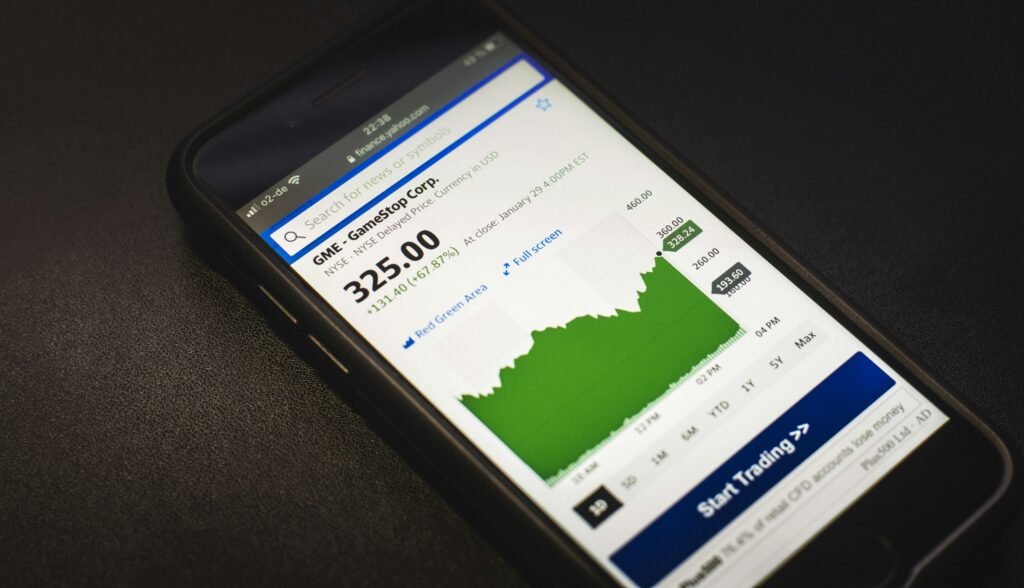 Mobitel s prikazom dioničkog grafa koji simbolizira špekulativno trgovanje i rizik